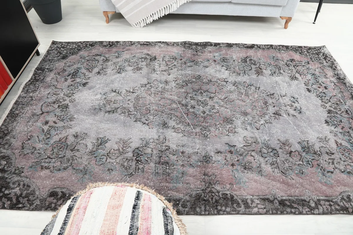 View of the rug from a different angle, capturing the overall faded appearance