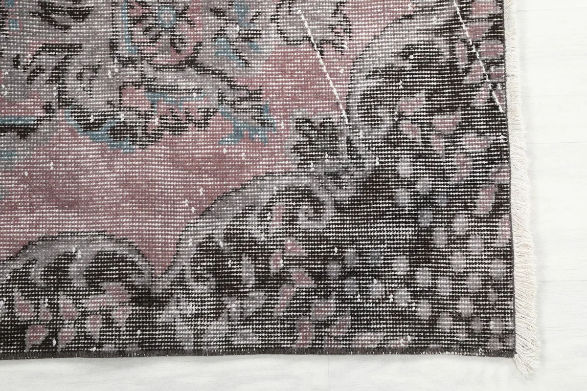 Detailed view of the rug's corner, showing the floral border and short fringe