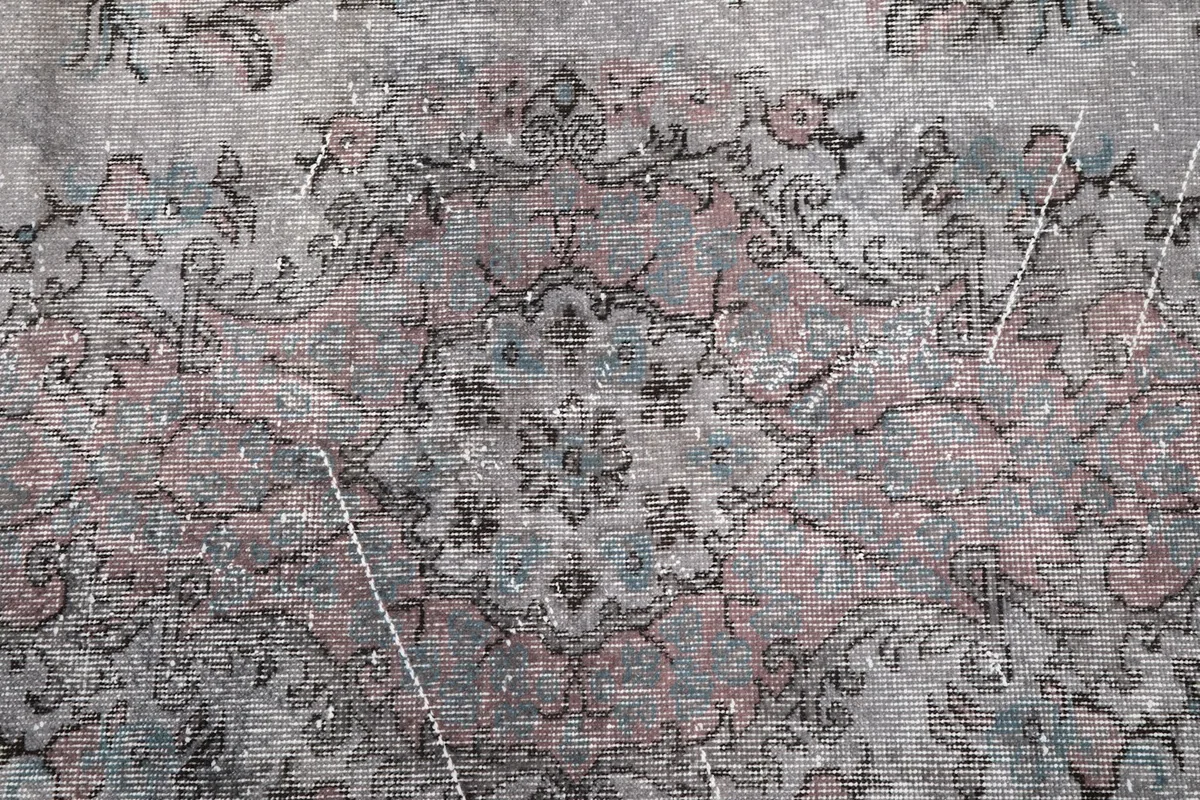 Detailed view of the rug's pattern, showing the interplay of rose, gray, and charcoal tones