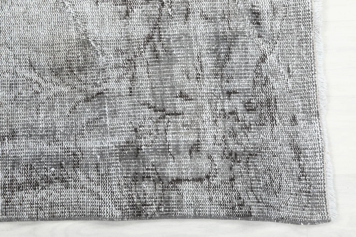 Detailed view of the Charcoal Faded Abstract Rug's surface, revealing the hand-knotted wool pile and distressed look.