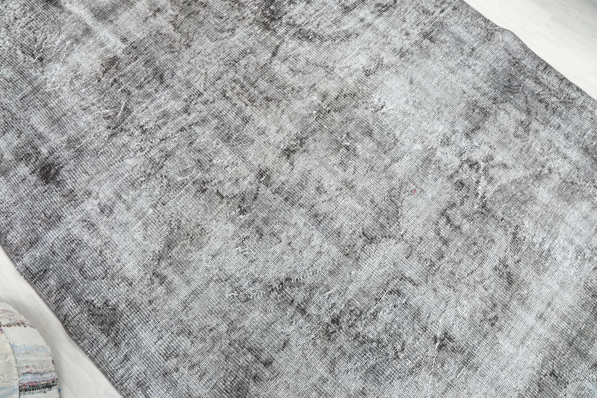 Diagonal view of the Charcoal Faded Abstract Rug, capturing the full range of its gray and charcoal hues.