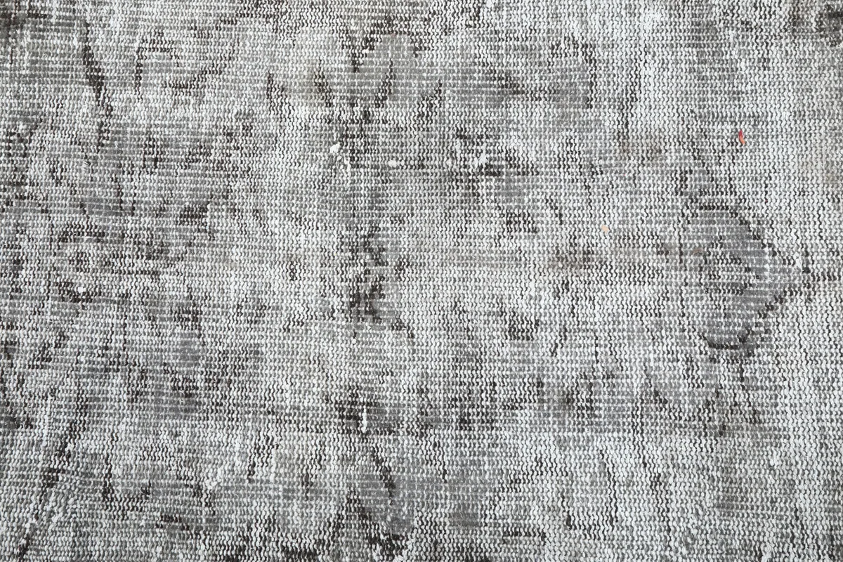 Close-up of the low pile of the Charcoal Faded Abstract Rug, showing individual knots and faded areas.