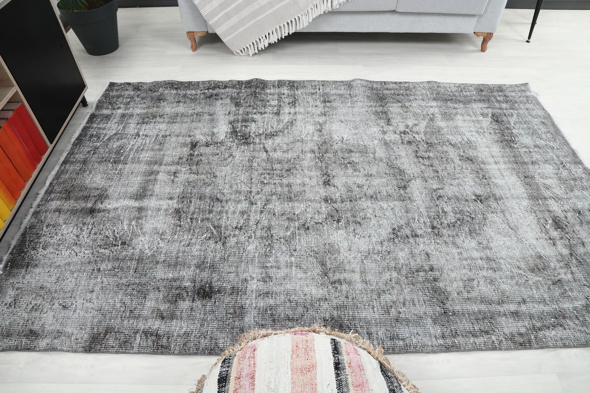 Wide shot of the Charcoal Faded Abstract Rug in a room, emphasizing its medium size and impact on the space.