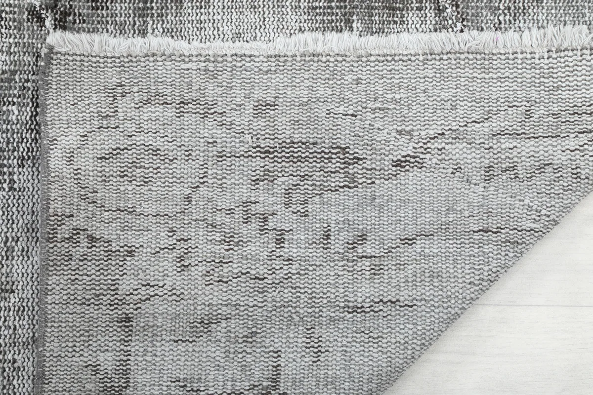Close-up of the back of the Charcoal Faded Abstract Rug, showing the tight hand-knotting and cotton foundation.