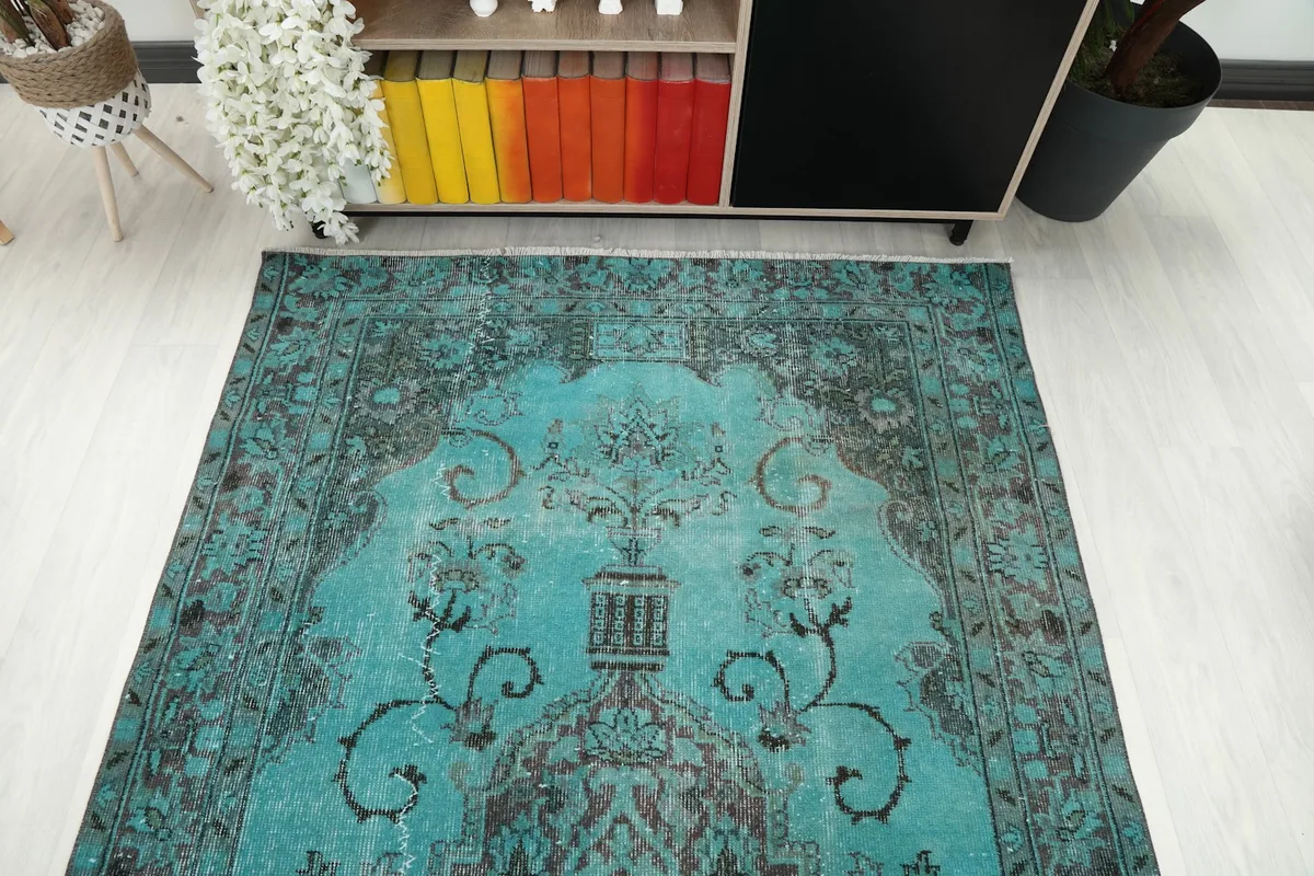 Overhead view focusing on one end of the blue vintage rug, showing pattern detail