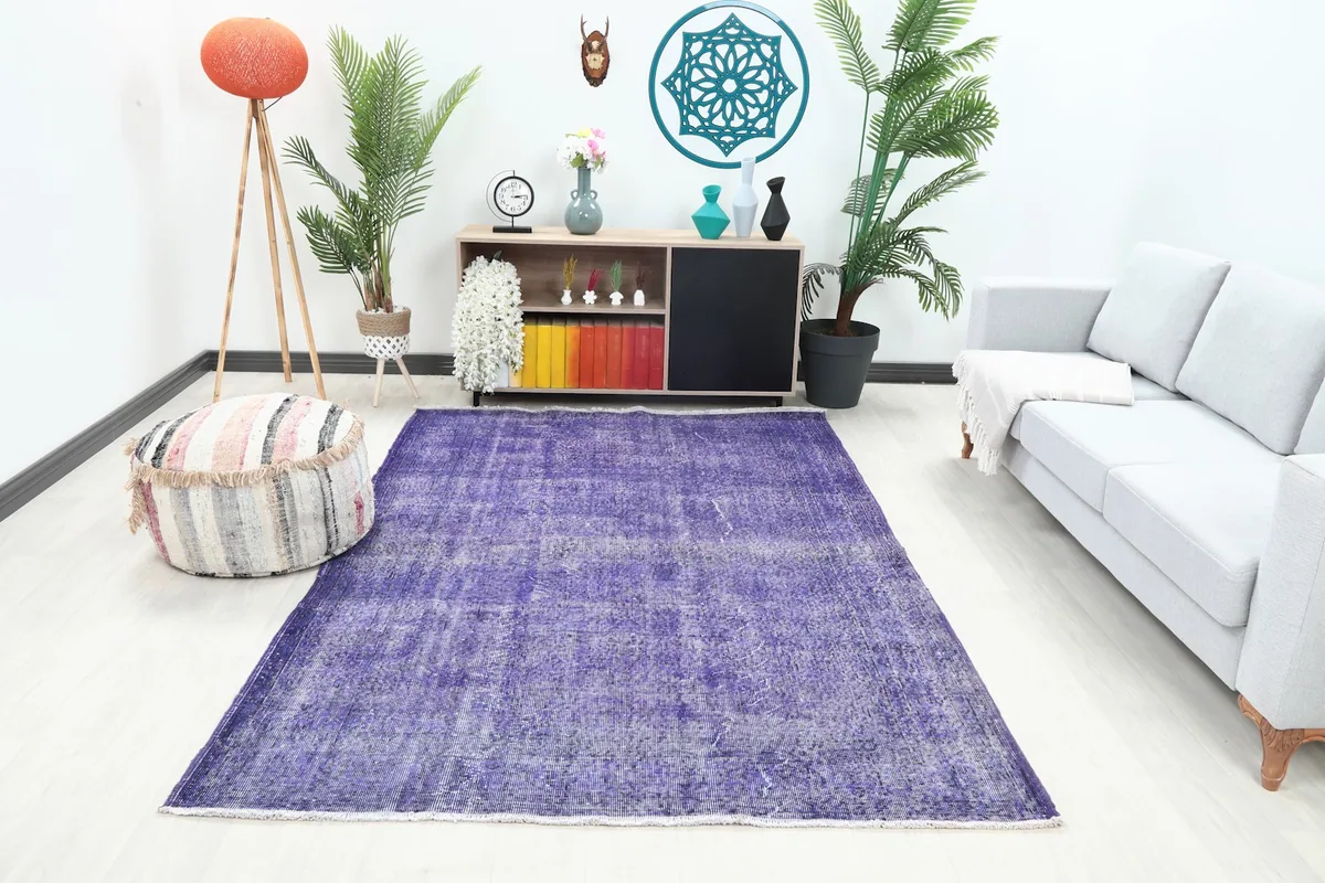 Purple distressed Anatolian rug in a contemporary living room setting with a light gray sofa and wooden furniture.
