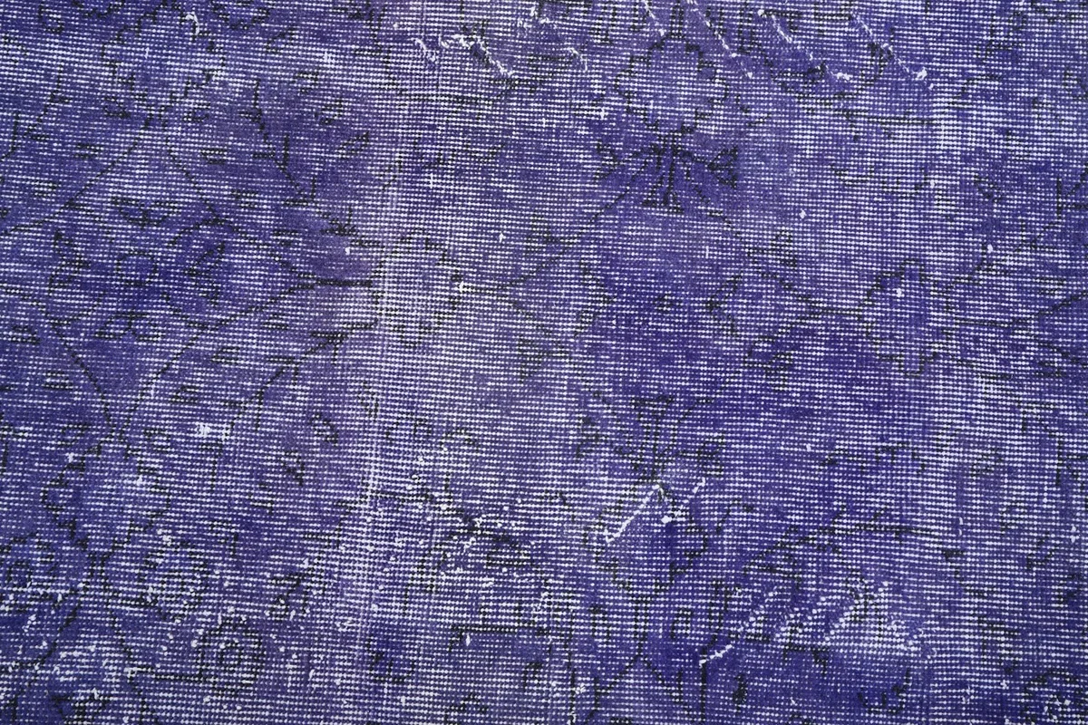 Close-up of the rug's pile, showing the texture and the lighter gray areas where the wool is more worn.
