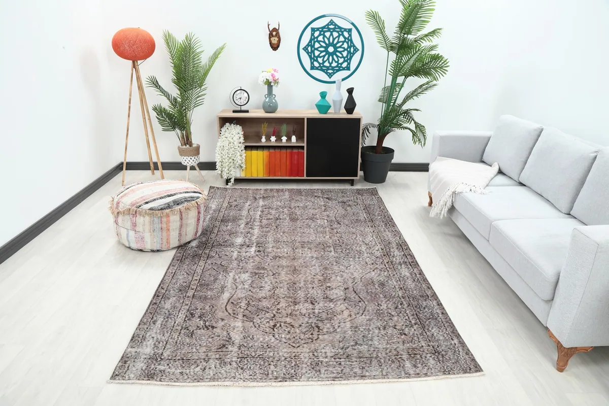 Charcoal gray vintage rug displayed in a living room setting with a light gray sofa and modern decor.
