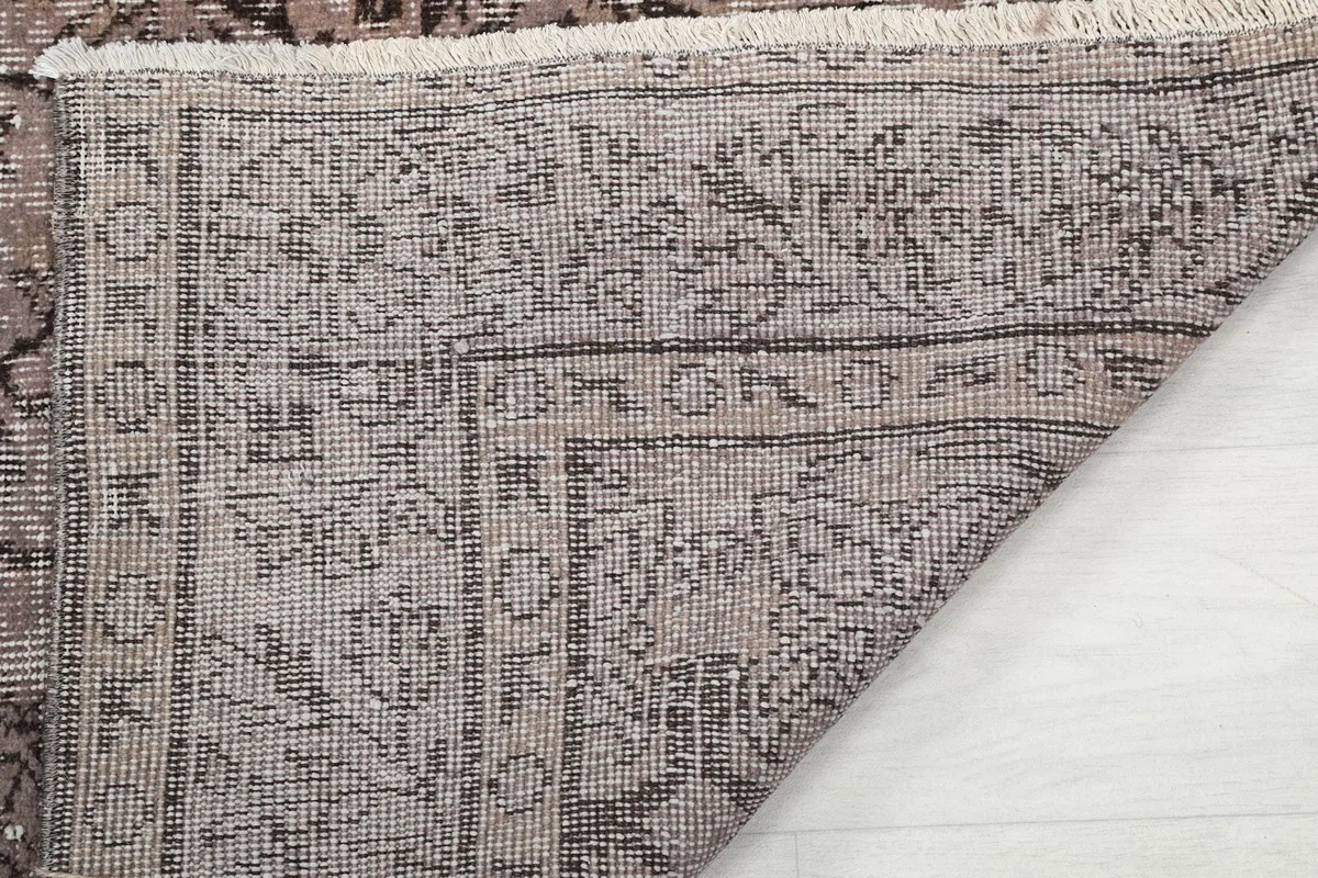 Close-up of the back of the rug, showing the knotting detail and the cotton foundation beneath the wool pile.