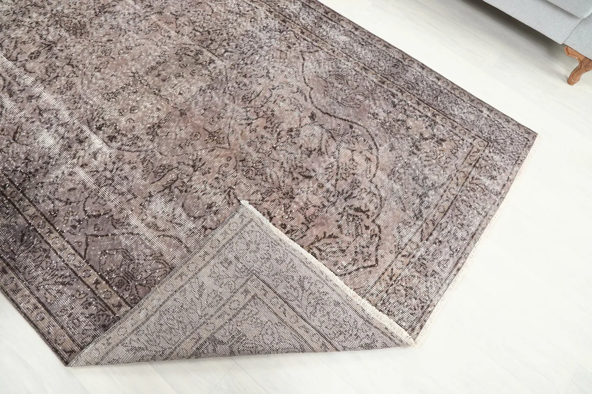 View of the rug folded back to reveal the cotton foundation and the reverse side of the hand-knotted construction.