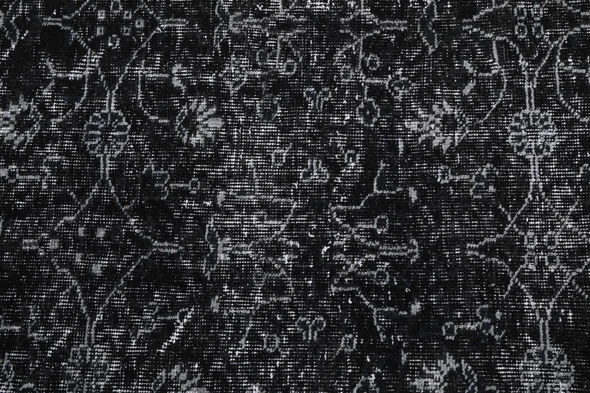 Close-up of the low pile and distressed texture of the black and gray wool rug