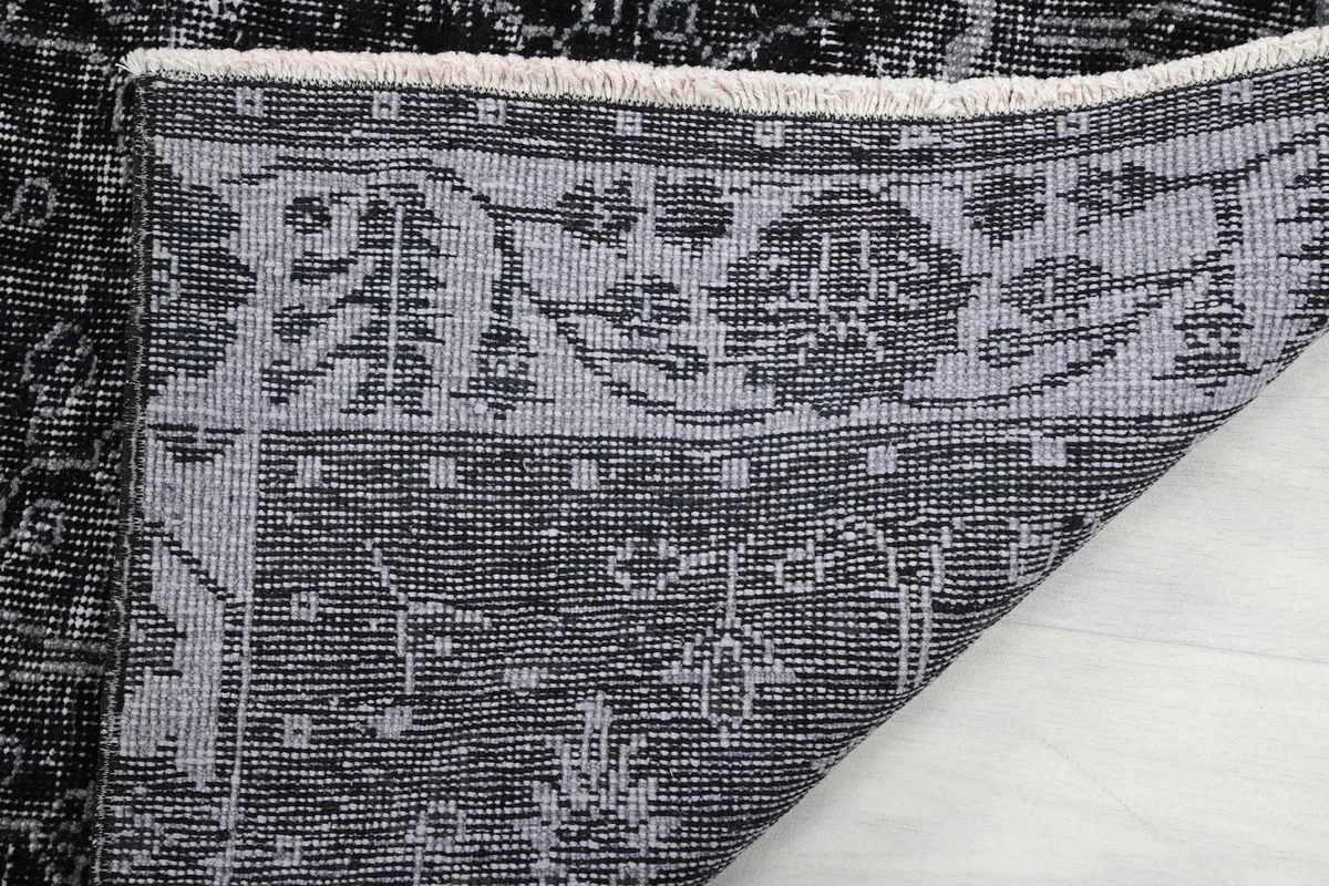Close-up of the rug's back, showing the hand-knotted construction and cotton foundation