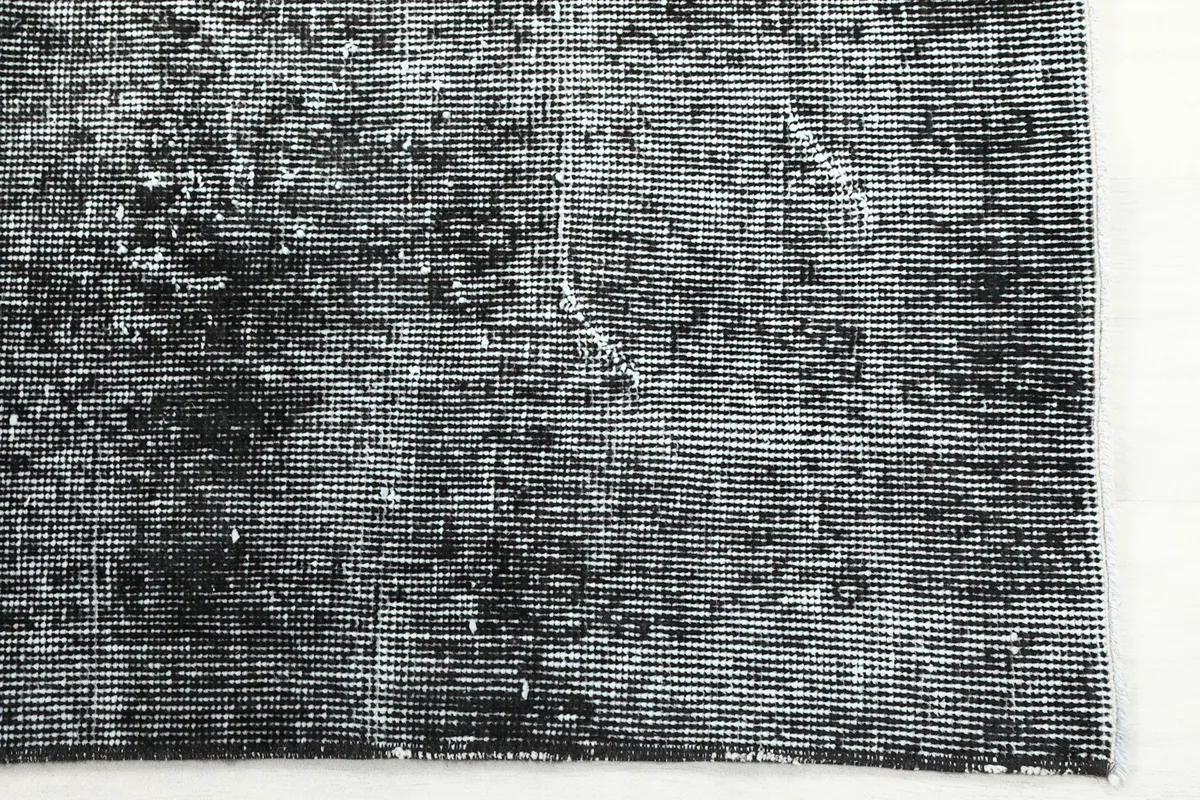 Detailed view of the hand-knotted wool pile and subtle geometric patterns