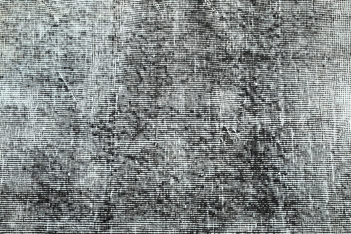 Close-up of the distressed surface showing the interplay of charcoal and gray fibers