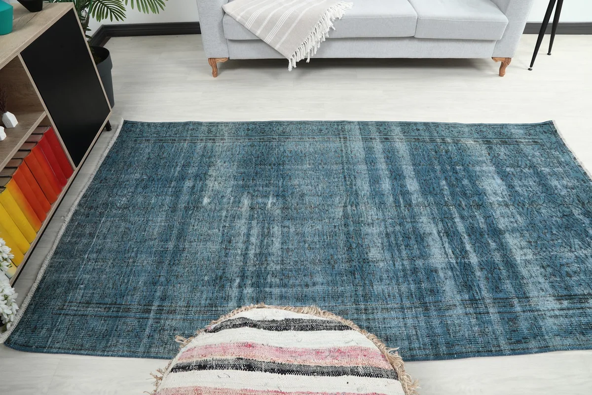 Full room view of the blue vintage rug, demonstrating its impact as a central decor piece.