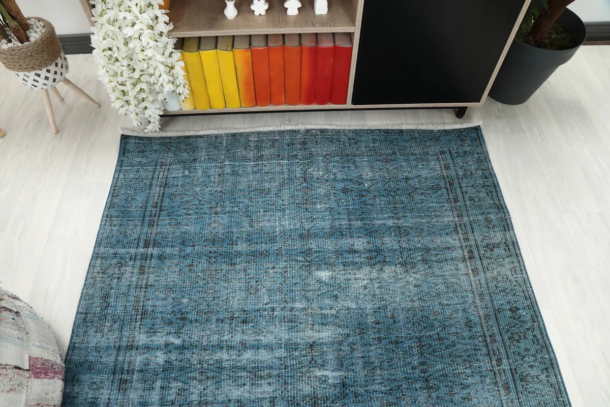 Overhead view of the blue vintage Anatolian rug, emphasizing its overall distressed appearance.