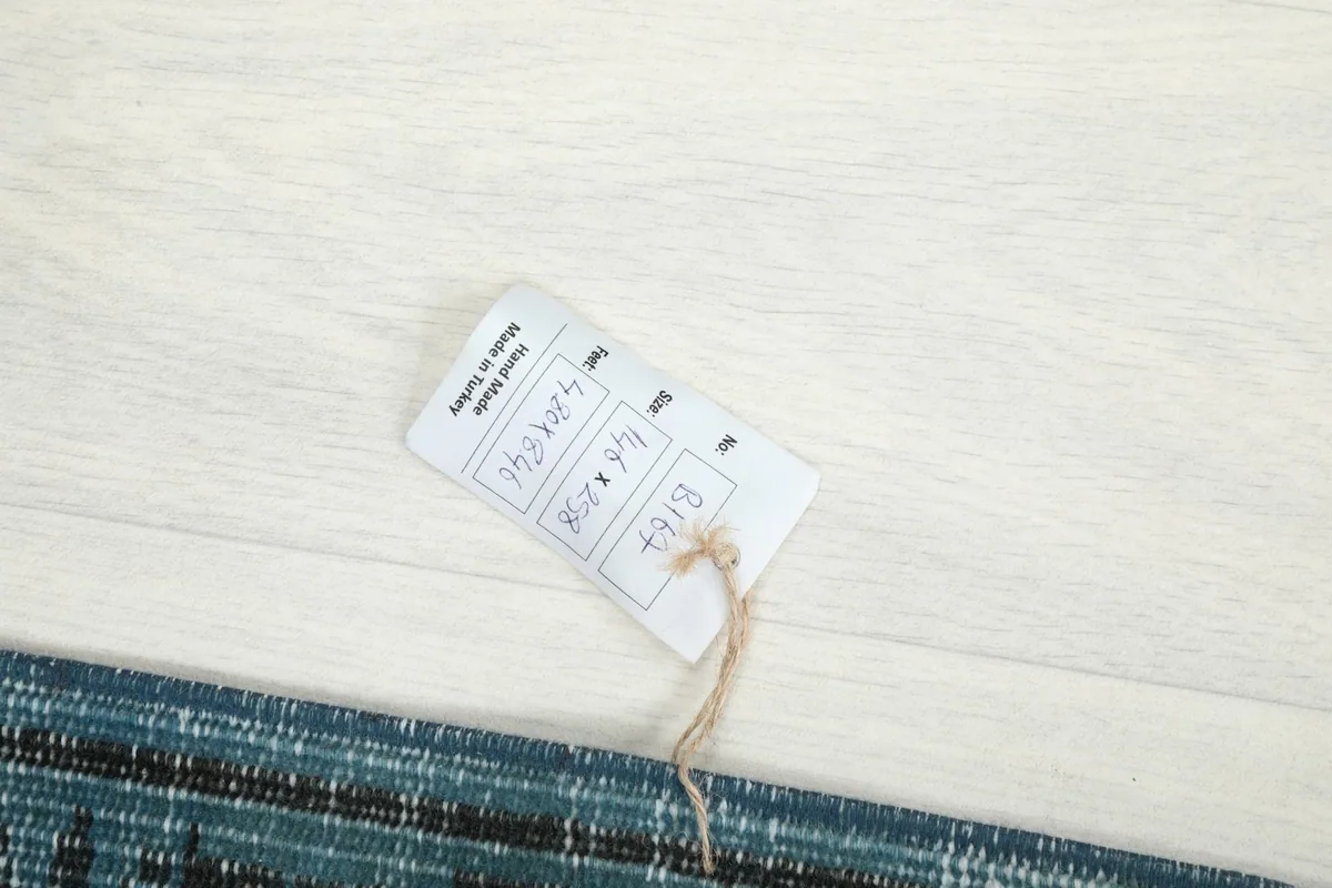 Product tag tied to the blue vintage rug, displaying size information and origin.