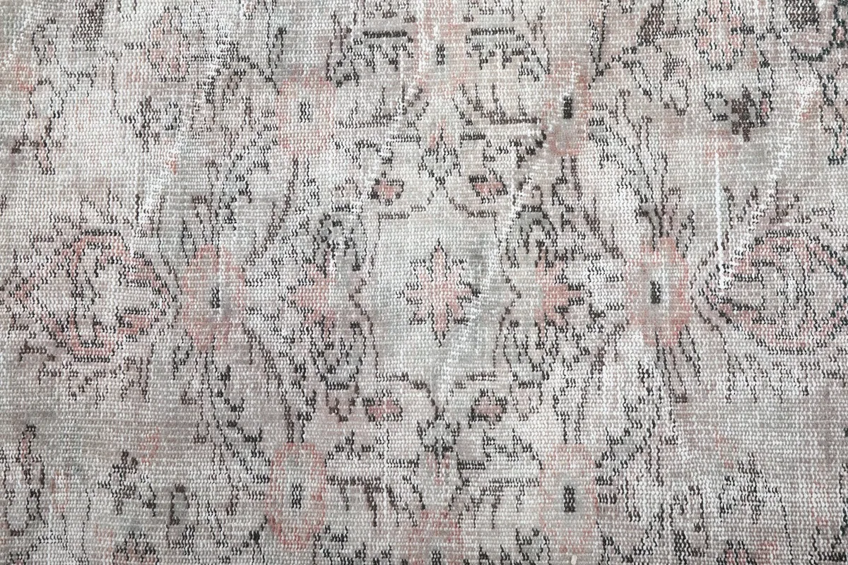 Detailed view of the central medallion design and surrounding patterns with faded colors