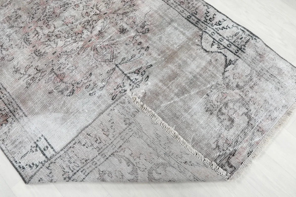 Folded corner of the rug showing the reverse side and the hand-knotted cotton foundation