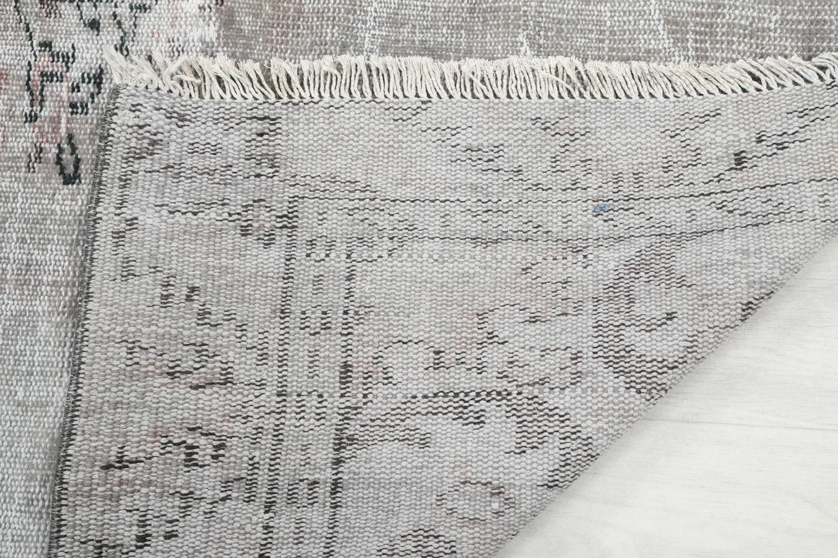 Close-up of the rug's fringe and the tightly woven back, demonstrating craftsmanship