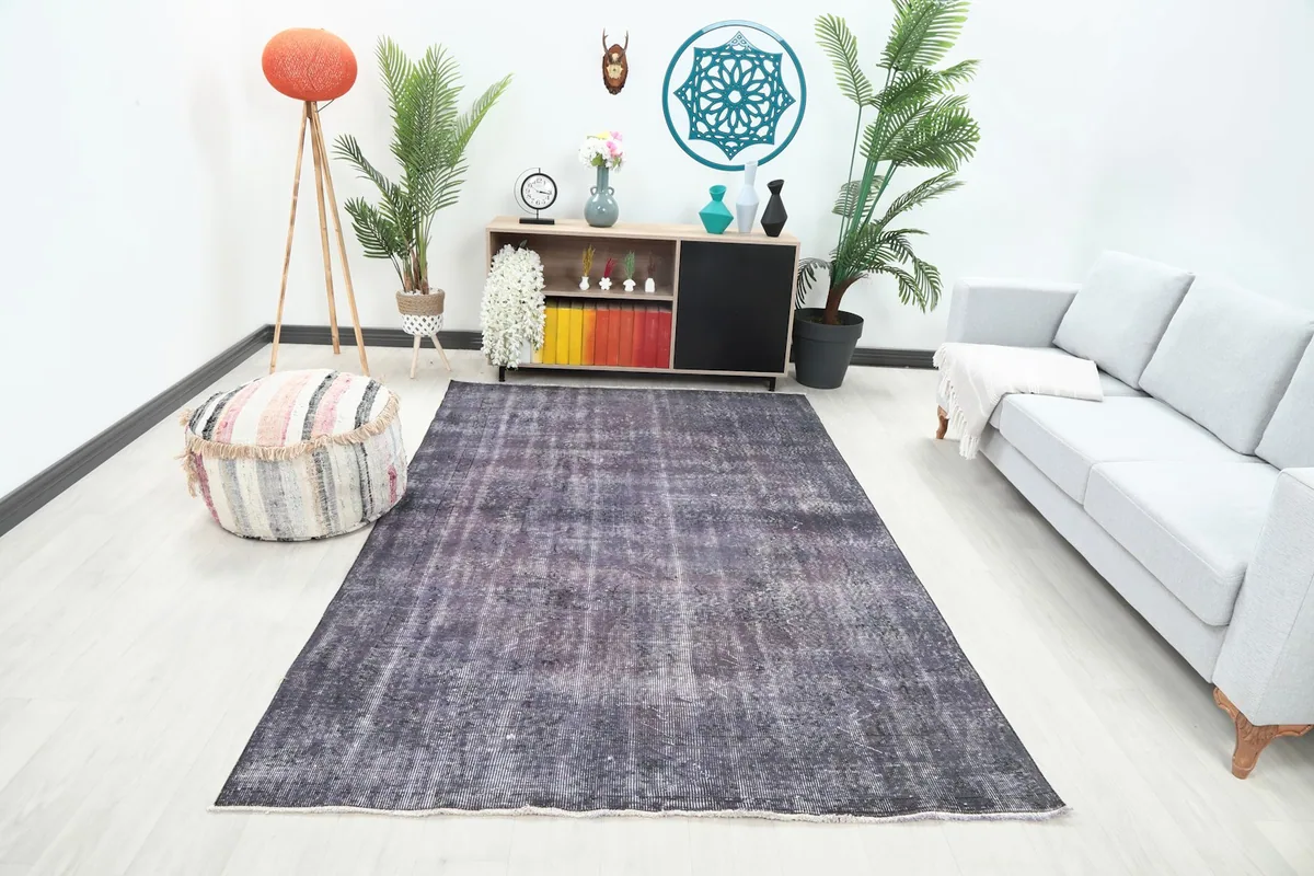 Purple vintage rug displayed in a bright living room setting with a light gray sofa and modern decor.