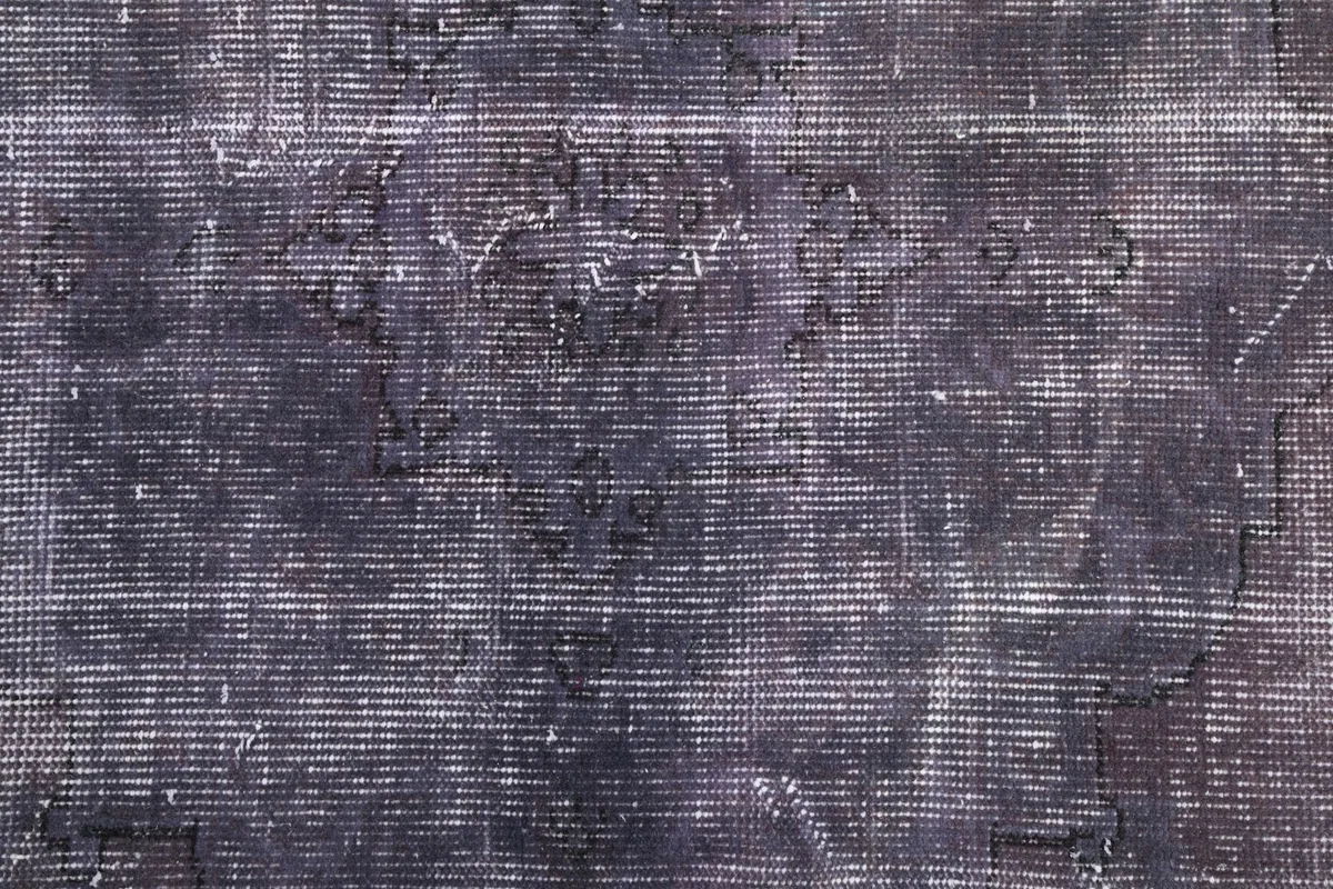 Detailed overhead shot of the rug's pile, emphasizing the fine hand-knotted wool and faded geometric motifs.