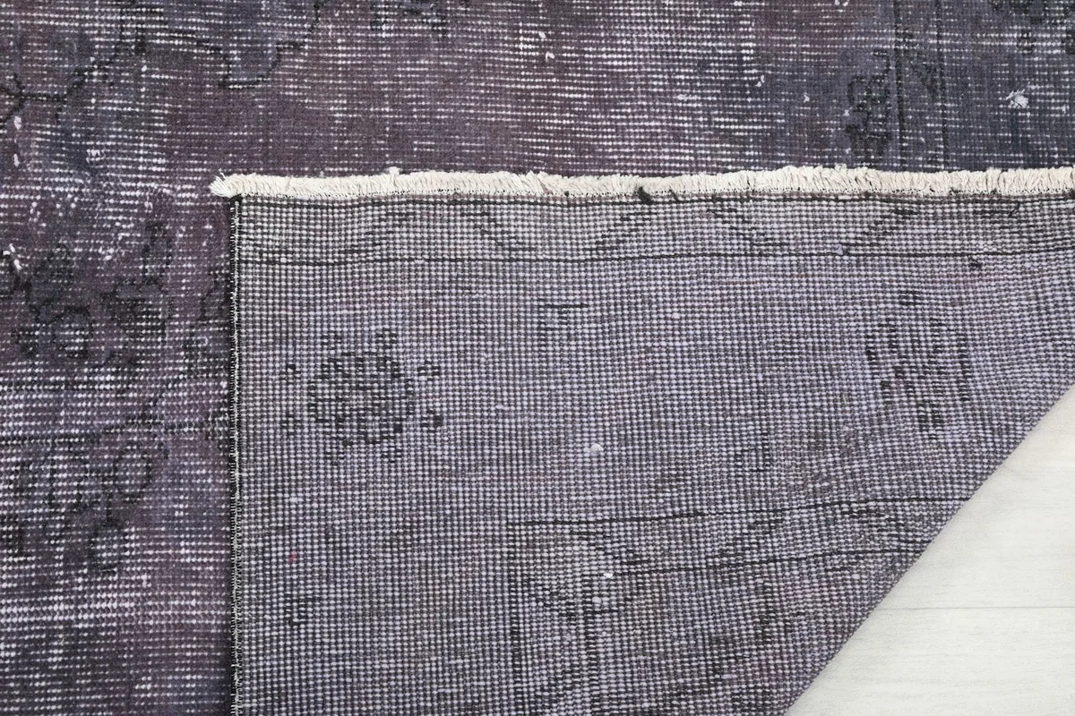 Close-up of the rug's back, showing the intricate foundation weave and a glimpse of the edge finishing.