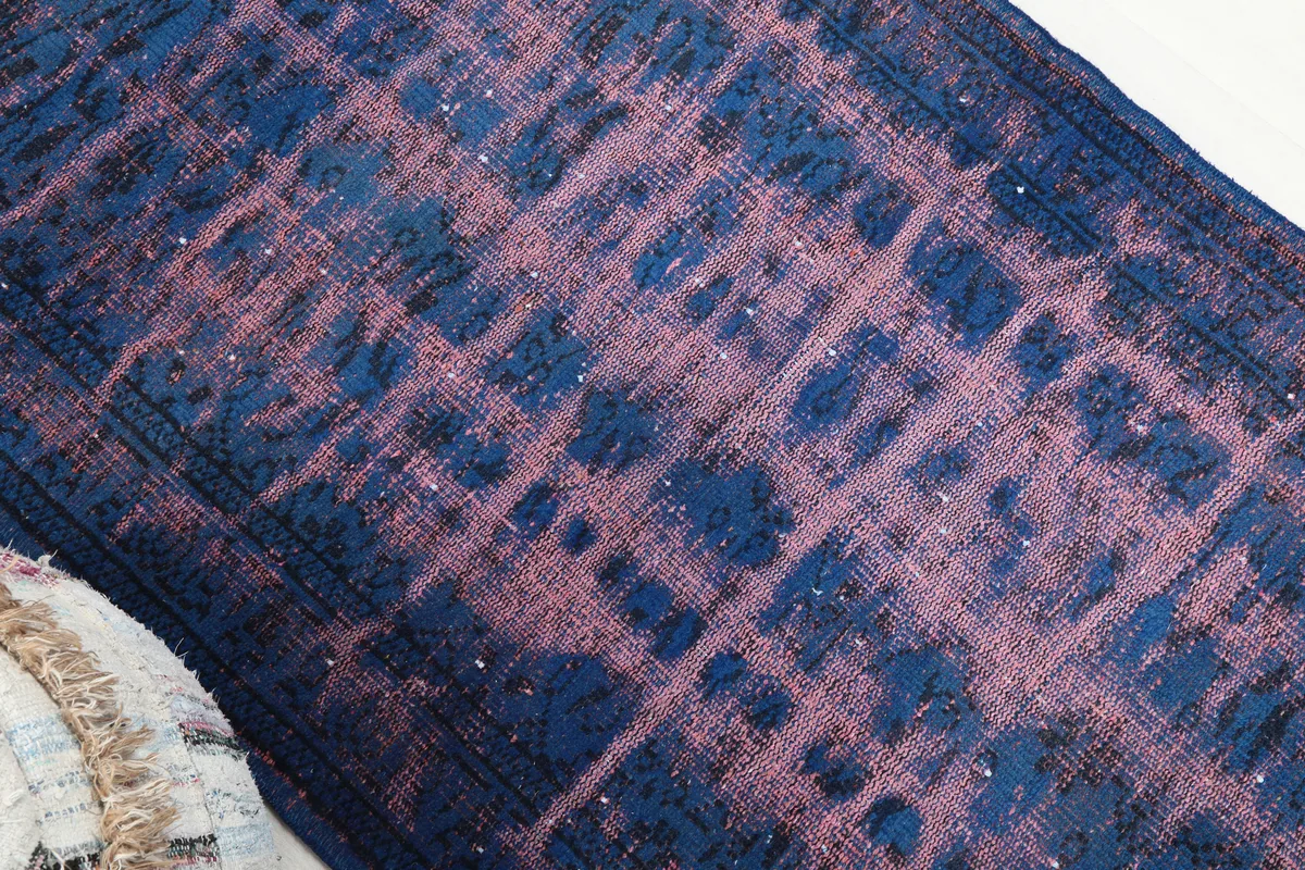 Angled view showing the distressed texture and color variation of the rug
