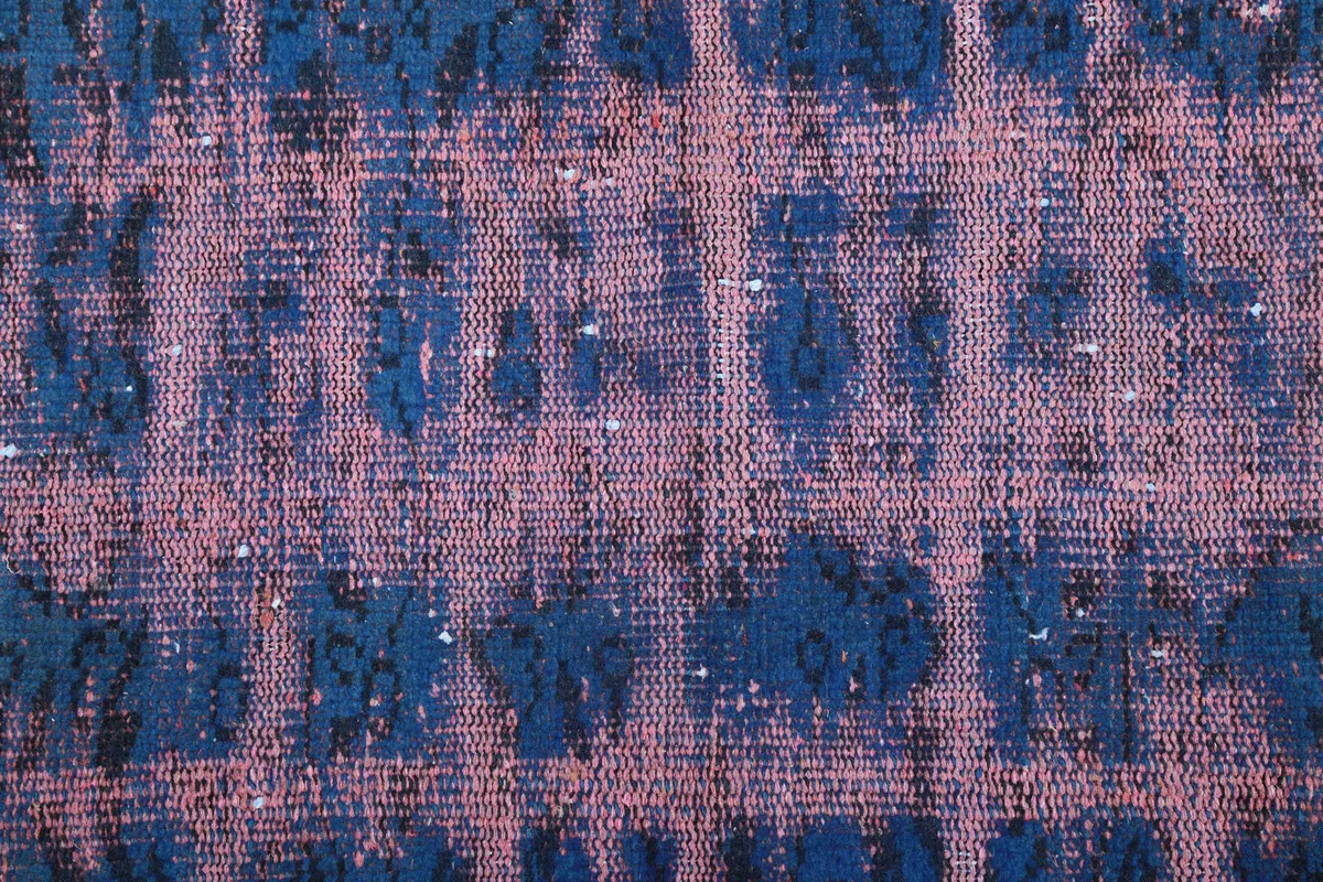 Close-up of the low pile and hand-knotted texture, showing blue and rose fibers