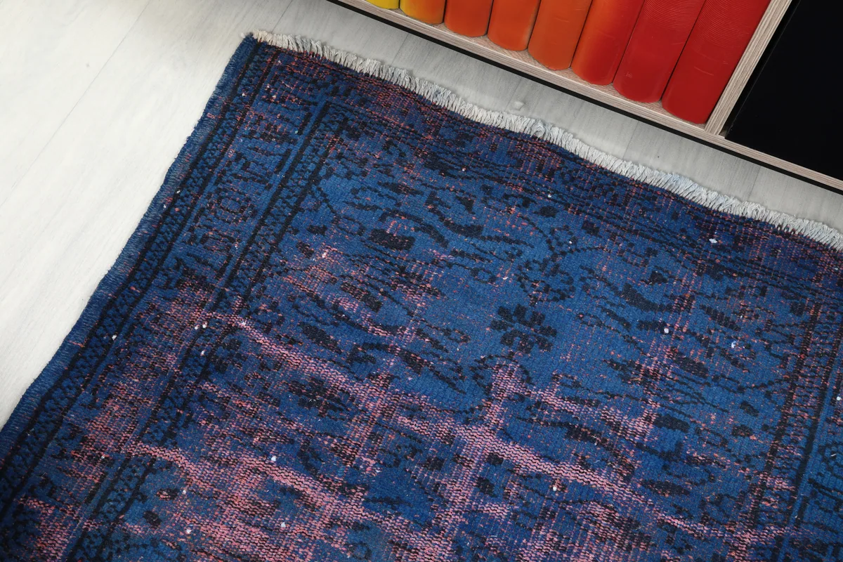 Detail view of the rug's surface, highlighting the faded rose and blue colors