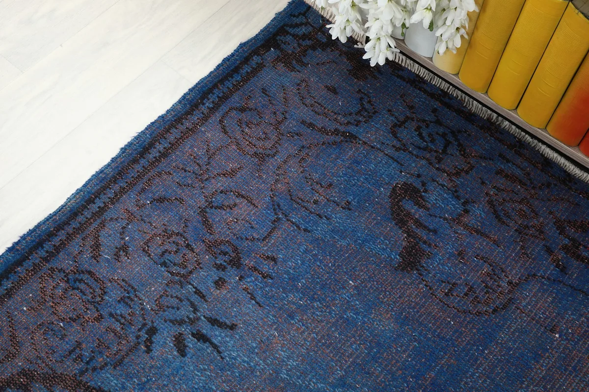 Detail of the rug's border pattern and the transition to the main blue field