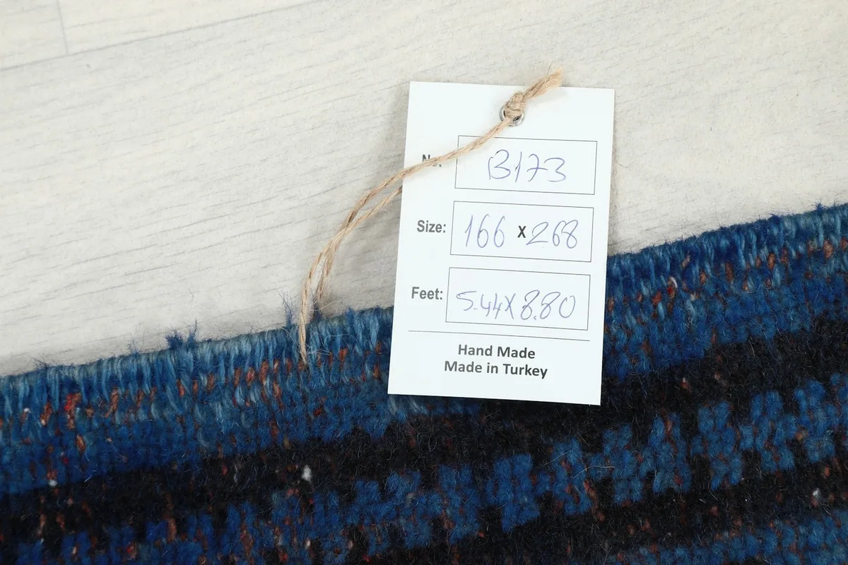 Product tag displaying the rug's size in centimeters and feet, and origin