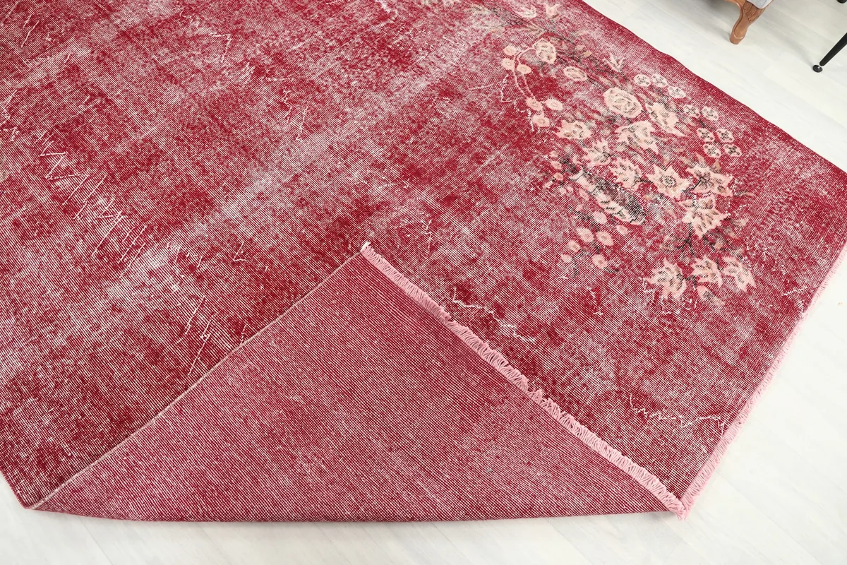 Corner of the rose rug folded to show the back of the hand-knotted cotton foundation
