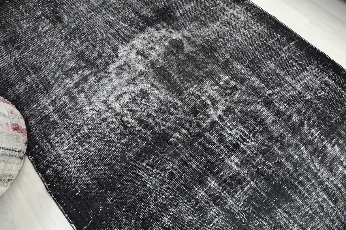 Detailed view of a faded central motif on the charcoal vintage rug