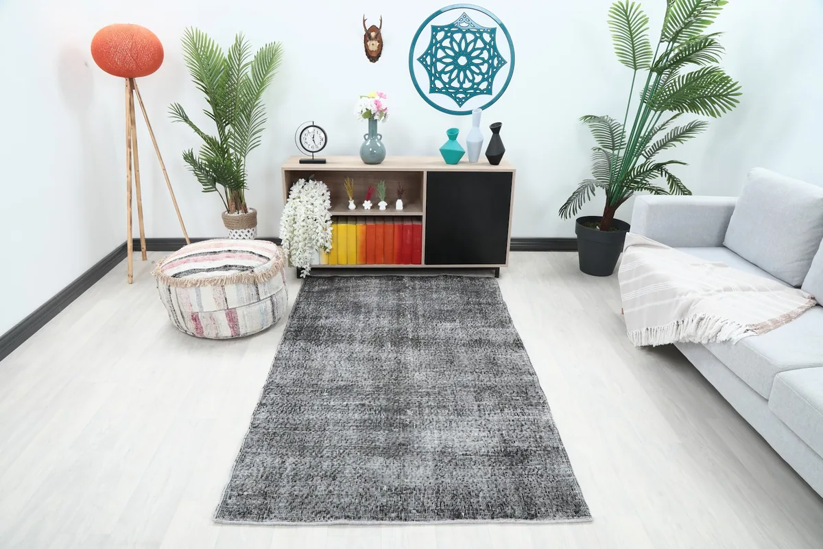 Charcoal vintage rug placed in a modern living room setting with light flooring