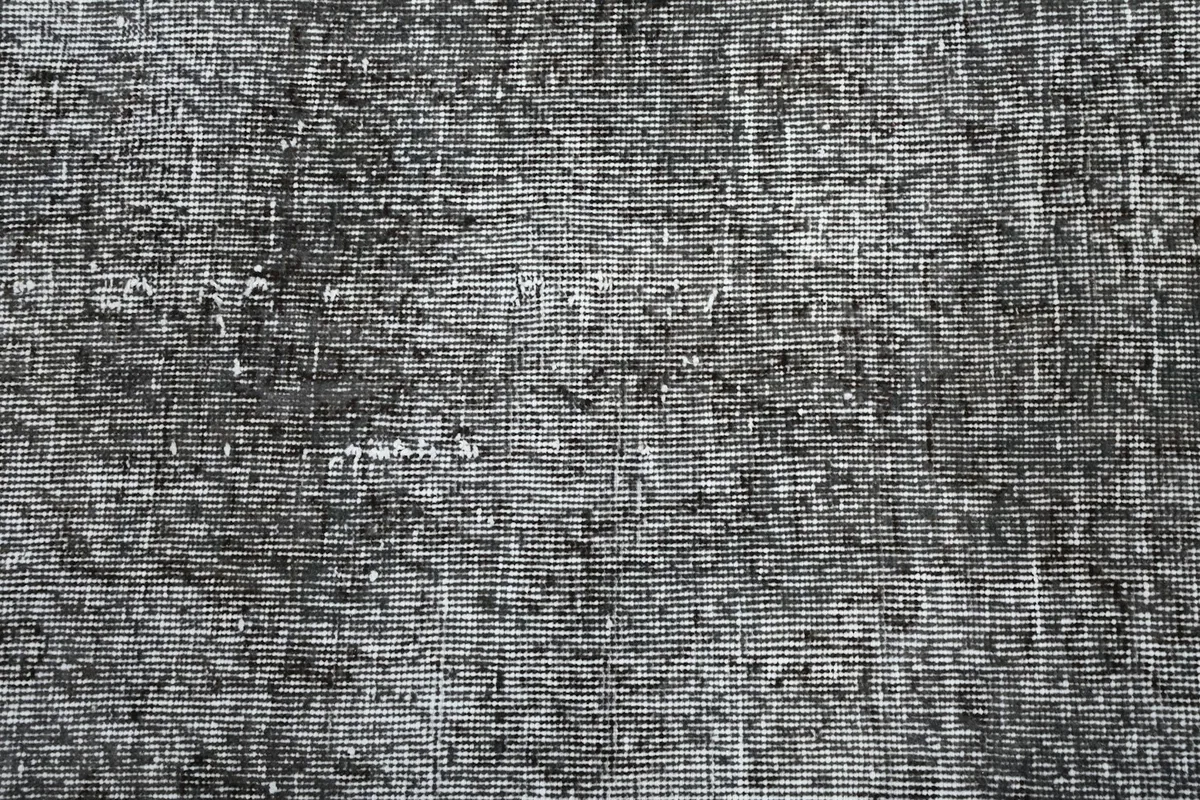Extreme close-up of the hand-knotted wool pile, showing individual knots and wear