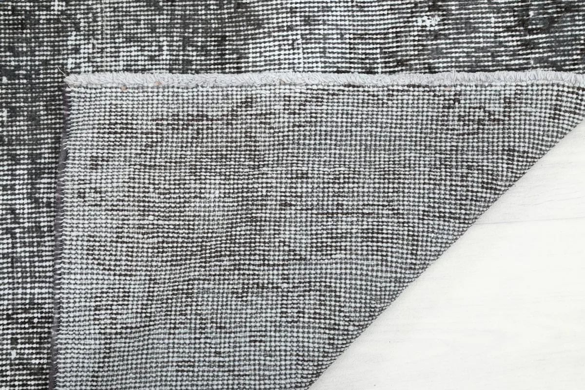 Detailed view of the rug's back, displaying the hand-knotted cotton foundation