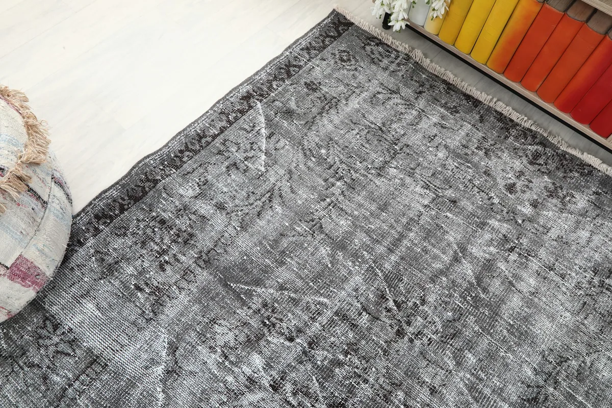 Corner view of the charcoal gray rug in the room, showing its placement near furniture