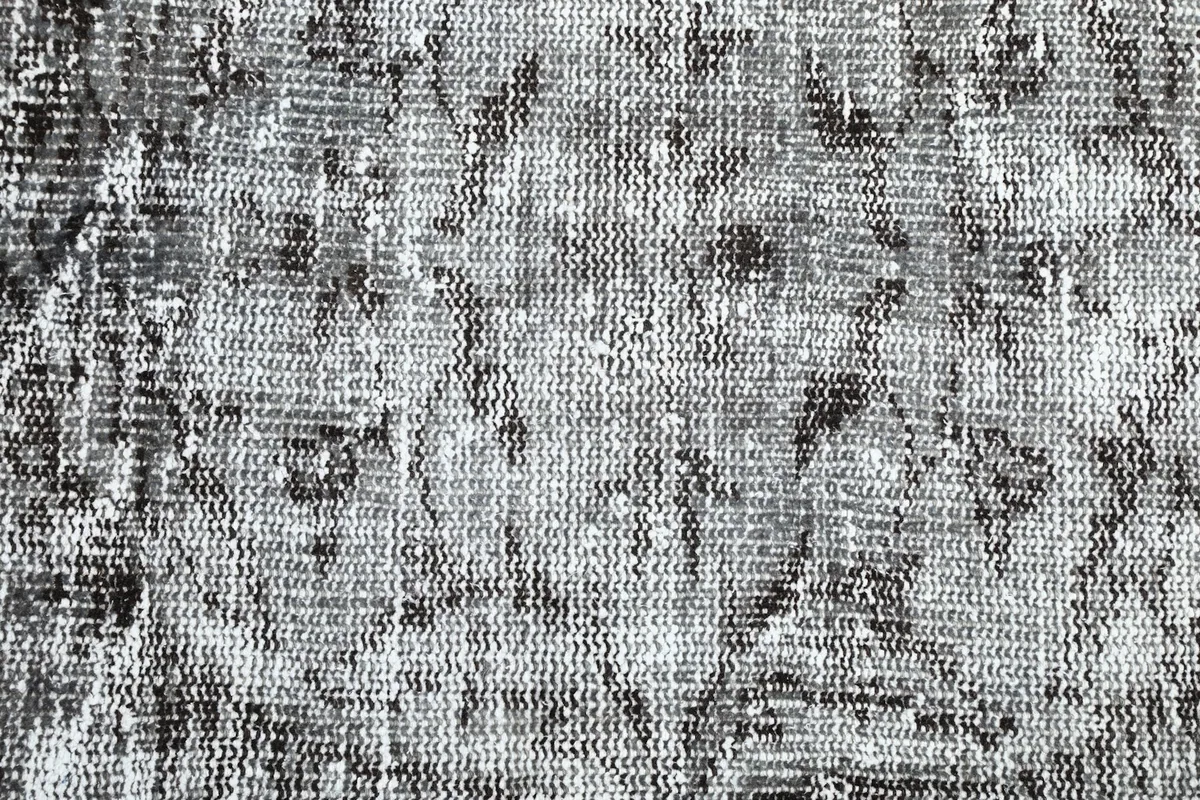 Detailed close-up of the hand-knotted wool pile, showing the distressed texture and knotting
