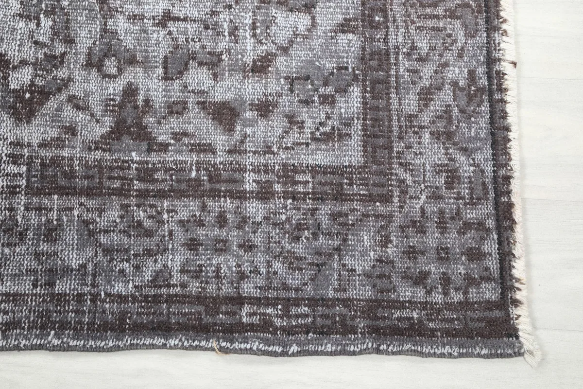 Close-up of the rug's edge, showing the intricate border details and subtle fringe