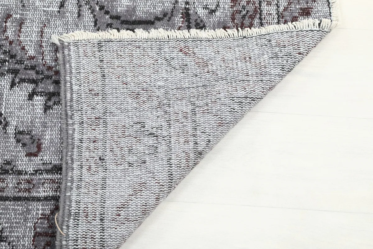 Underside of the rug showing the tight weave of the cotton foundation and fringes