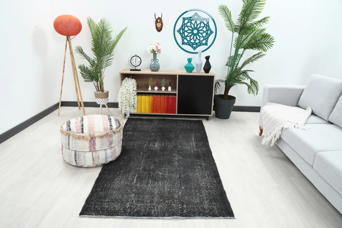 Charcoal vintage rug placed in a modern living room setting, showing its scale with furniture.