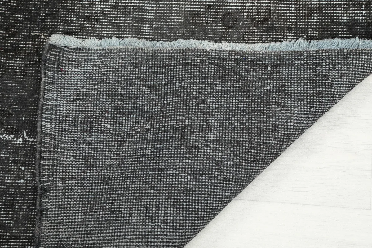 Close-up of the back of the rug, revealing the tight knotting on the cotton foundation.