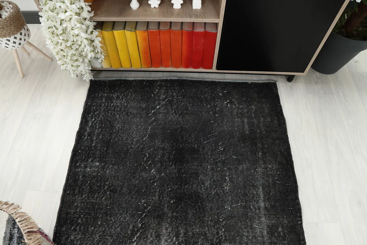 Overhead shot of the charcoal vintage rug, showcasing its rectangular shape and overall appearance in a room.