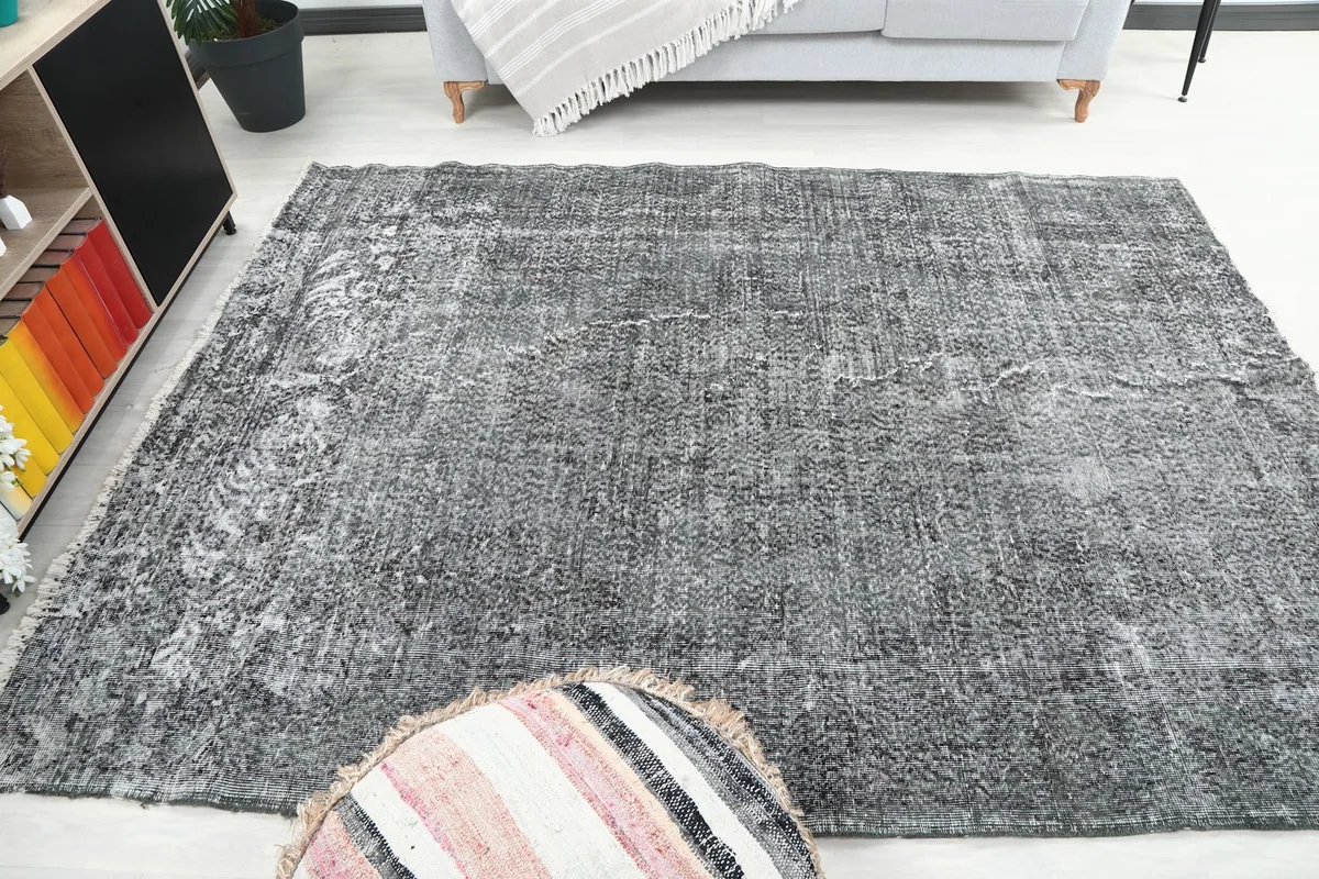 Area rug in a room, showing its scale relative to a sofa and ottoman
