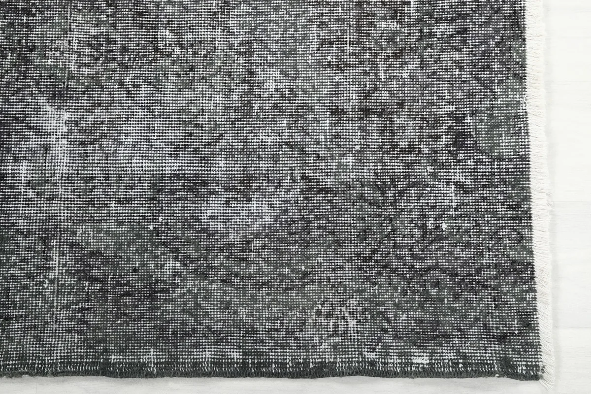 Detail of the rug's surface, highlighting the charcoal and gray variations and texture