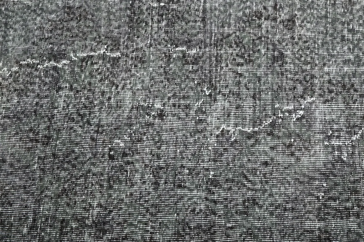 Close-up of the low wool pile, showing the hand-knotted texture and faded areas