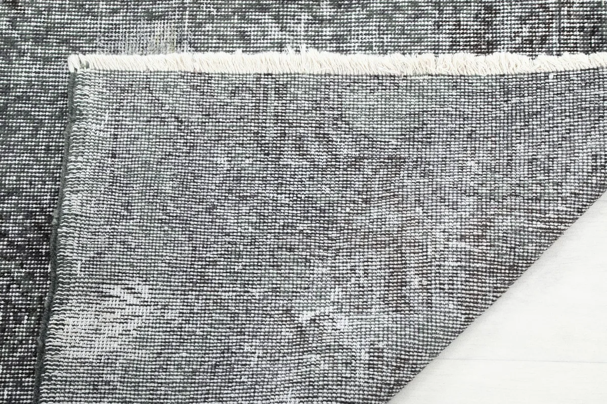 Underside of the rug, showing the cotton foundation and hand-knotted construction