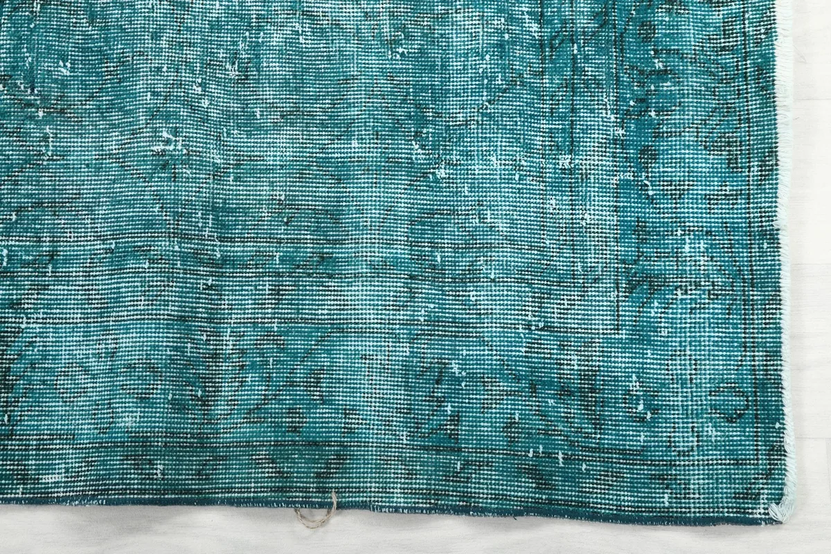 Detailed view of the rug's edge, showing the hand-knotted construction and subtle color shifts.
