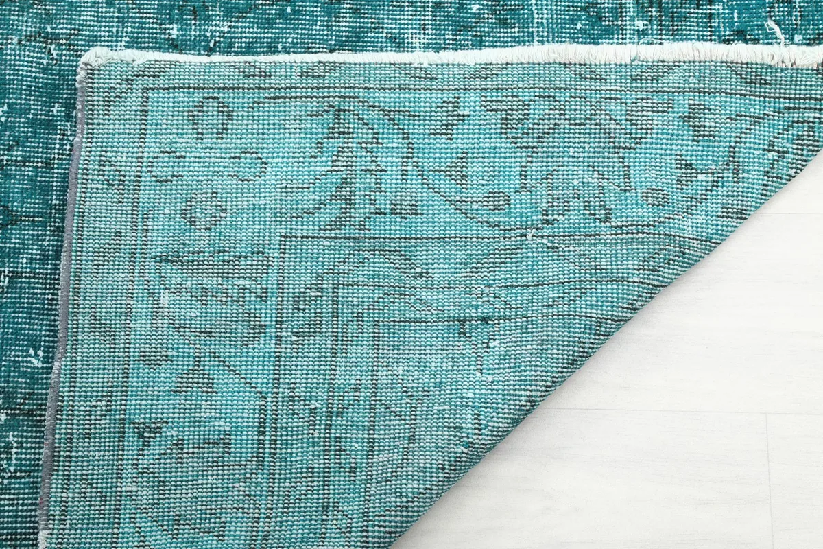 Close-up of the rug's back, revealing the intricate knotting and cotton foundation.